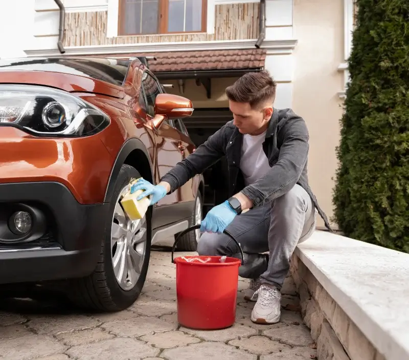 Lavage auto à domicile Tessancourt-sur-Aubette : professionnel intervenant sur un véhicule